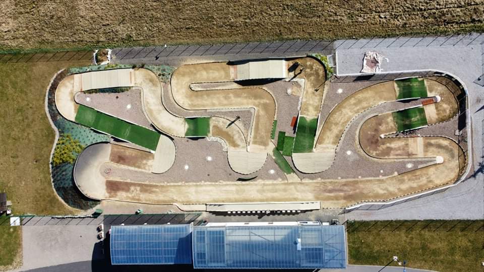 Vue drone du circuit MGA88 à Golbey — tracé mixte de 350 mètres, paddock et stands visibles en bas.